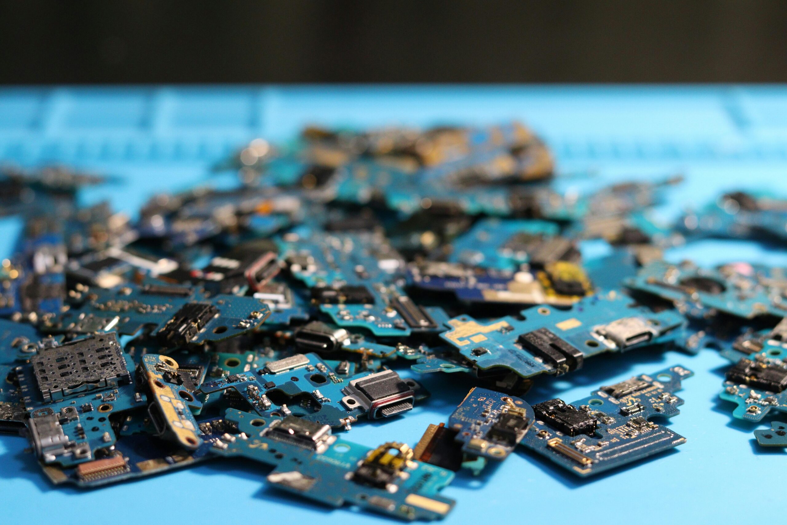 Home Pile of disassembled circuit boards on a blue surface. Perfect for tech themes.